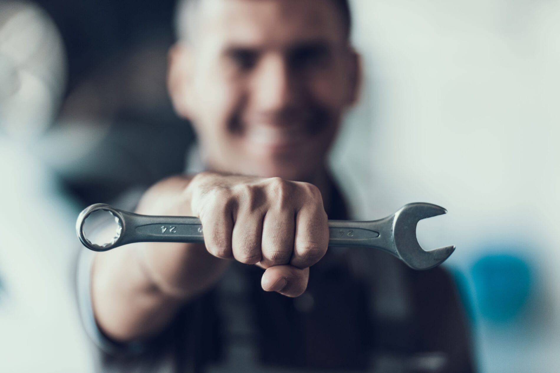 Auto Mechanic with Tool on Blurred Background